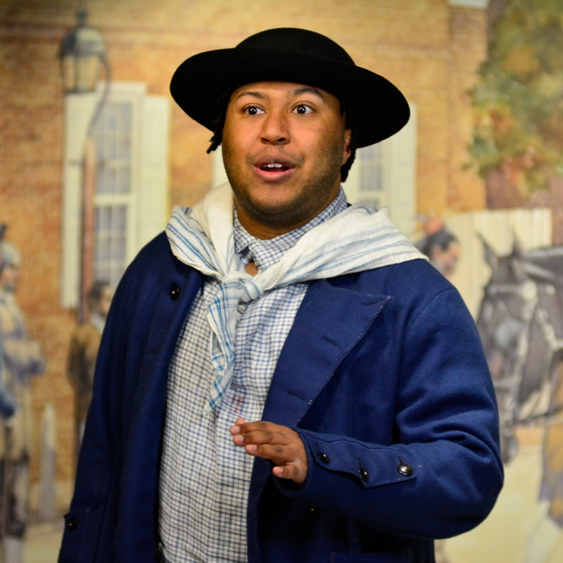 A Black actor in a costume of an 18th century American sailor.